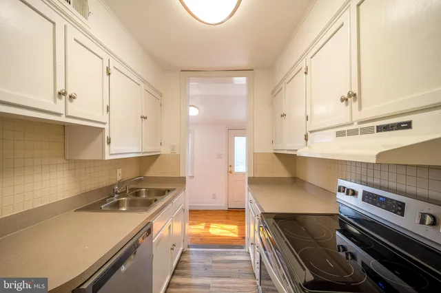 a kitchen with a sink and a stove top oven