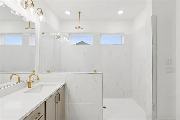 a bathroom with a sink a shower and a mirror