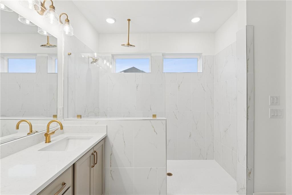 1041 Pine Bark Lane Canton, GA 30114 - Photo 11 of 19 a bathroom with a sink a shower and a mirror
