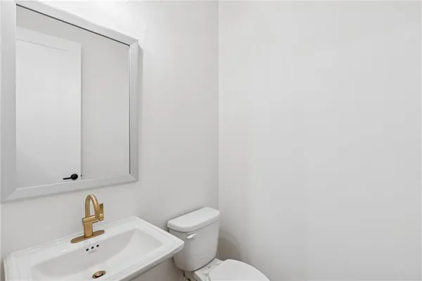 a bathroom with a sink a toilet and mirror