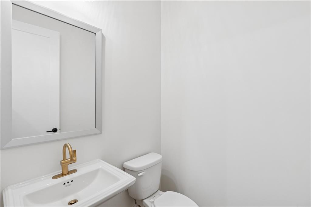 1041 Pine Bark Lane Canton, GA 30114 - Photo 5 of 19 a bathroom with a sink a toilet and mirror