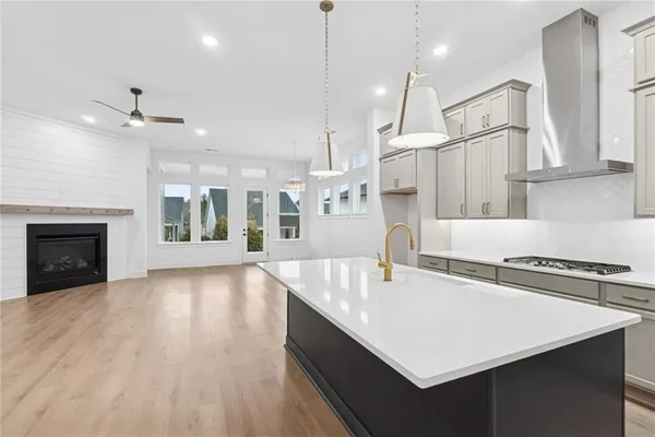 a kitchen with kitchen island a stove a sink a center island and wooden floor