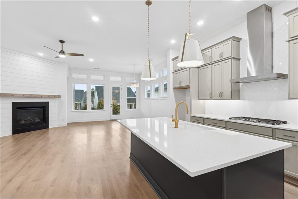 1041 Pine Bark Lane Canton, GA 30114 - Photo 6 of 19 a kitchen with kitchen island a stove a sink a center island and wooden floor