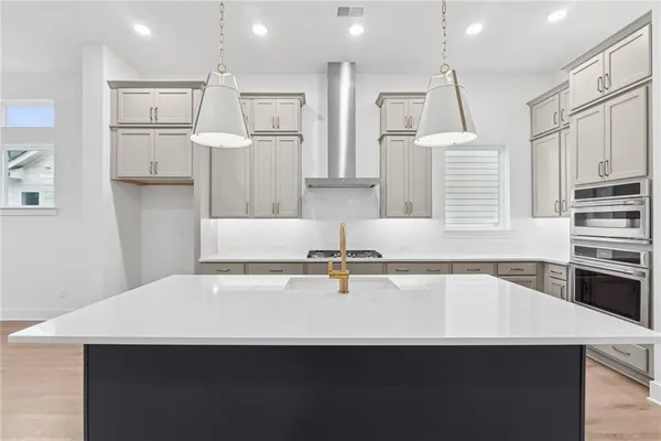 a kitchen with stainless steel appliances a sink a stove a refrigerator and cabinets