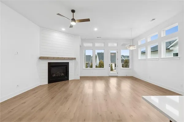 an empty room with windows and fireplace