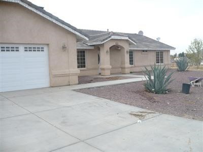 15464 Navajo Road Apple Valley, CA 92307 - Photo 1 of 1 a front view of a house with a yard and garage
