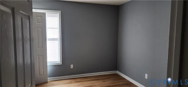 a view of a small space with wooden floor and a window