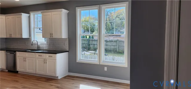 a kitchen with stainless steel appliances granite countertop a stove a sink and a granite counter tops with white cabinets