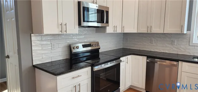 a kitchen with granite countertop white cabinets and white appliances