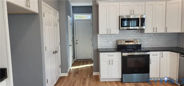 a kitchen with stainless steel appliances a stove a microwave and cabinets