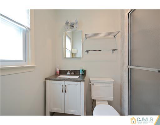 10 Midland Road Edison, NJ 08820 - Photo 13 of 18 a bathroom with a toilet a sink a vanity and mirror
