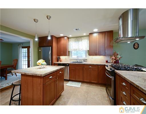 10 Midland Road Edison, NJ 08820 - Photo 7 of 18 a kitchen with granite countertop a sink stove and cabinets