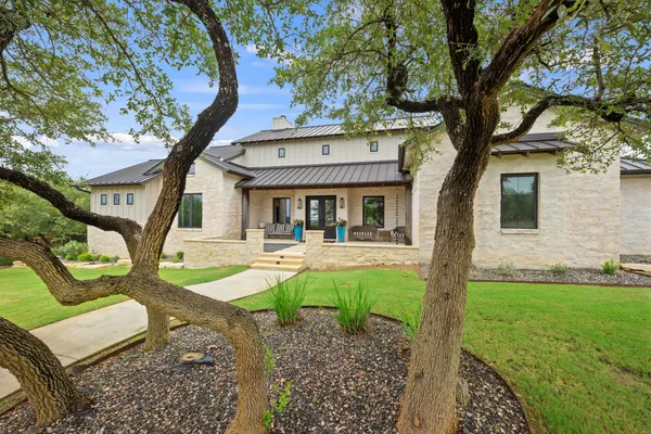 a view of a house with backyard and a tree