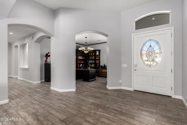 a view of a dining room and livingroom with furniture wooden floor a chandelier