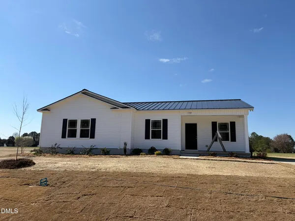 a view of a white house with a yard