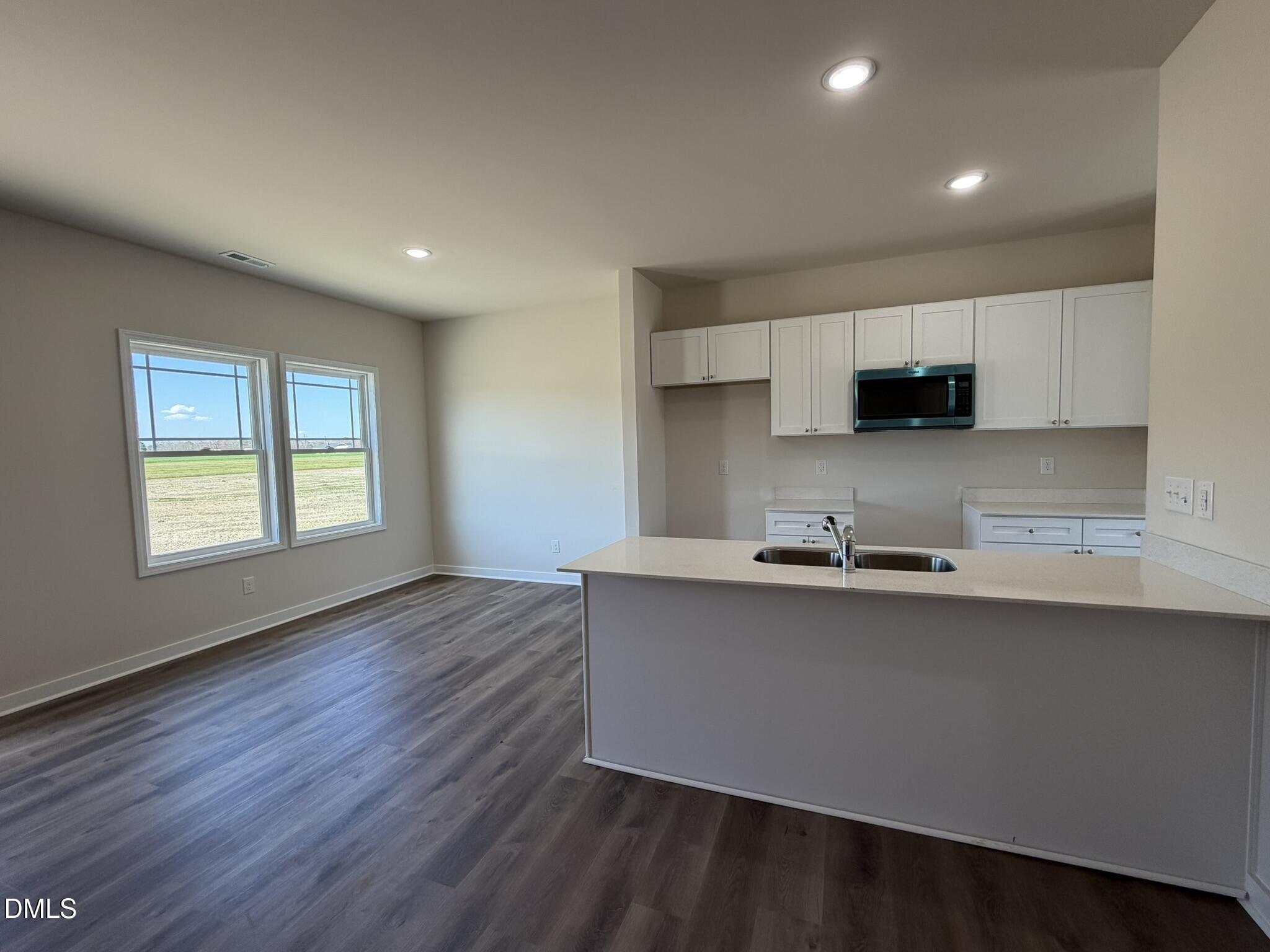 159 Jacobs Ridge Drive Four Oaks, NC 27524 - Photo 3 of 19 a kitchen with stainless steel appliances a sink a stove a microwave a refrigerator a cabinets and wooden floor