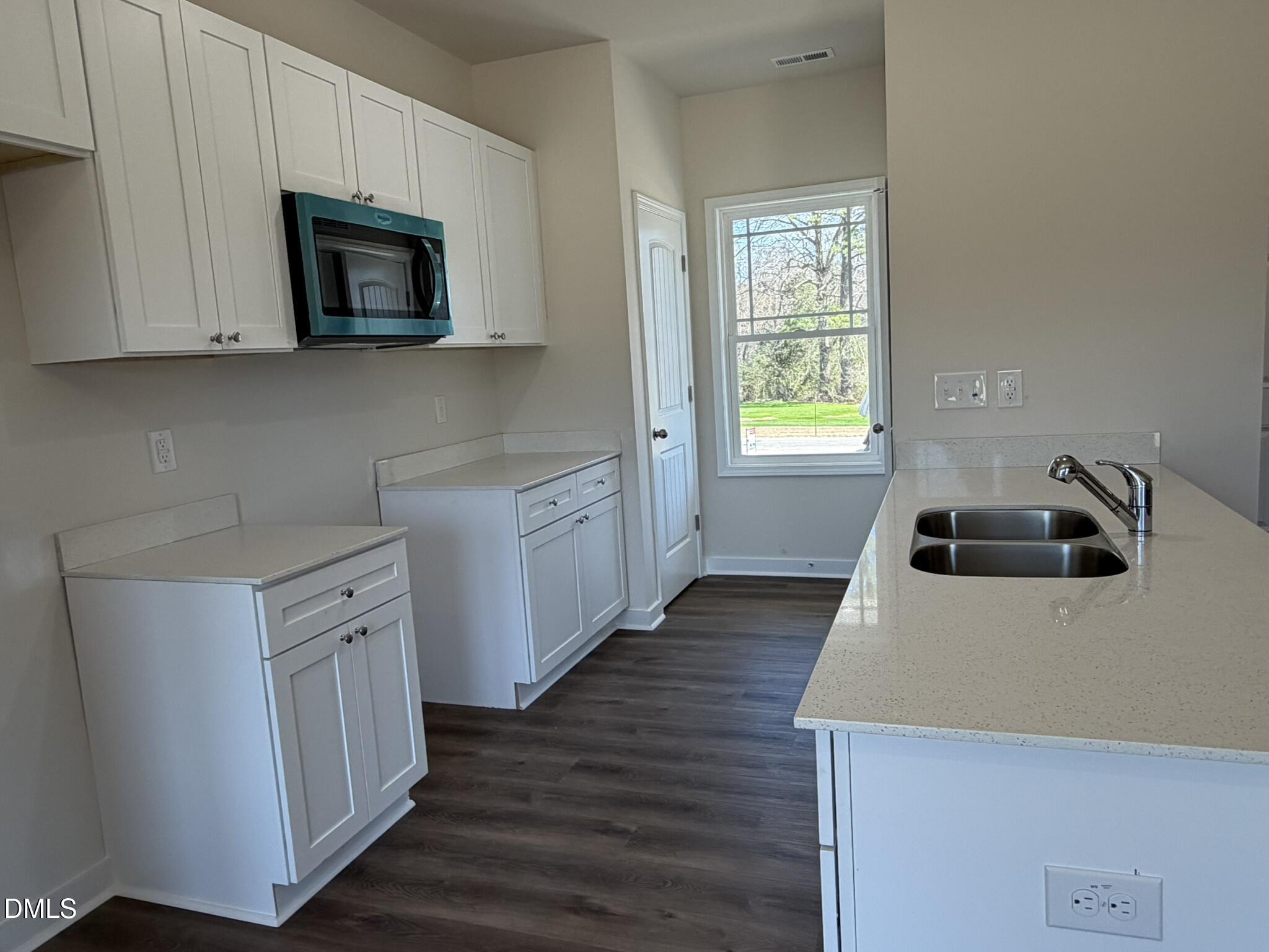 159 Jacobs Ridge Drive Four Oaks, NC 27524 - Photo 6 of 19 a kitchen with a sink a microwave and cabinets