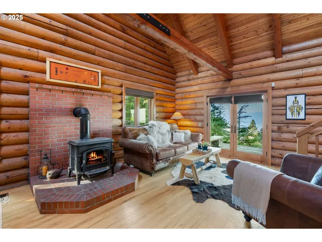 a living room with furniture a fireplace and large windows