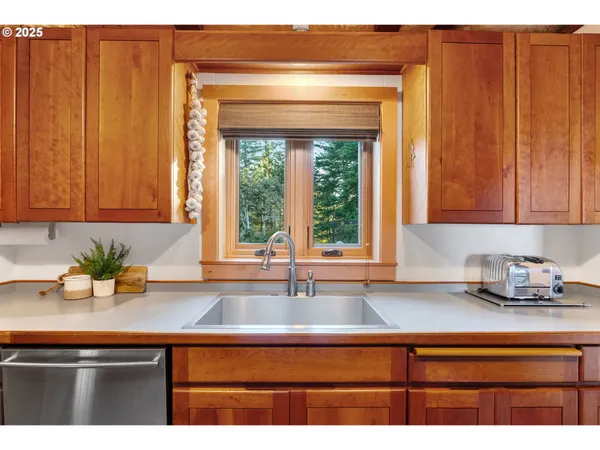 a kitchen with stainless steel appliances granite countertop a sink window and cabinets