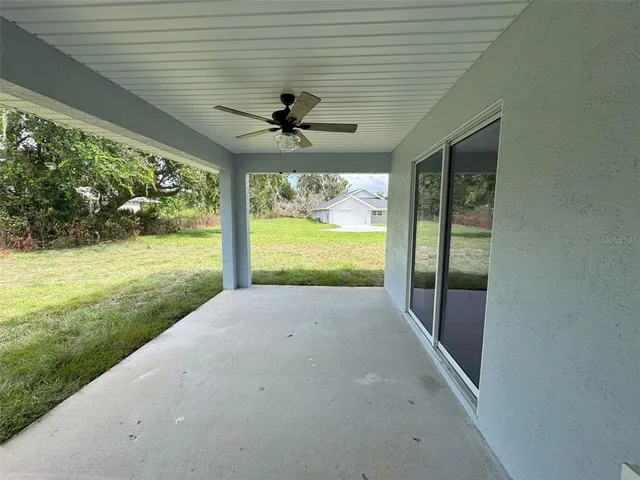 a view of a porch in front of a house with a big yard