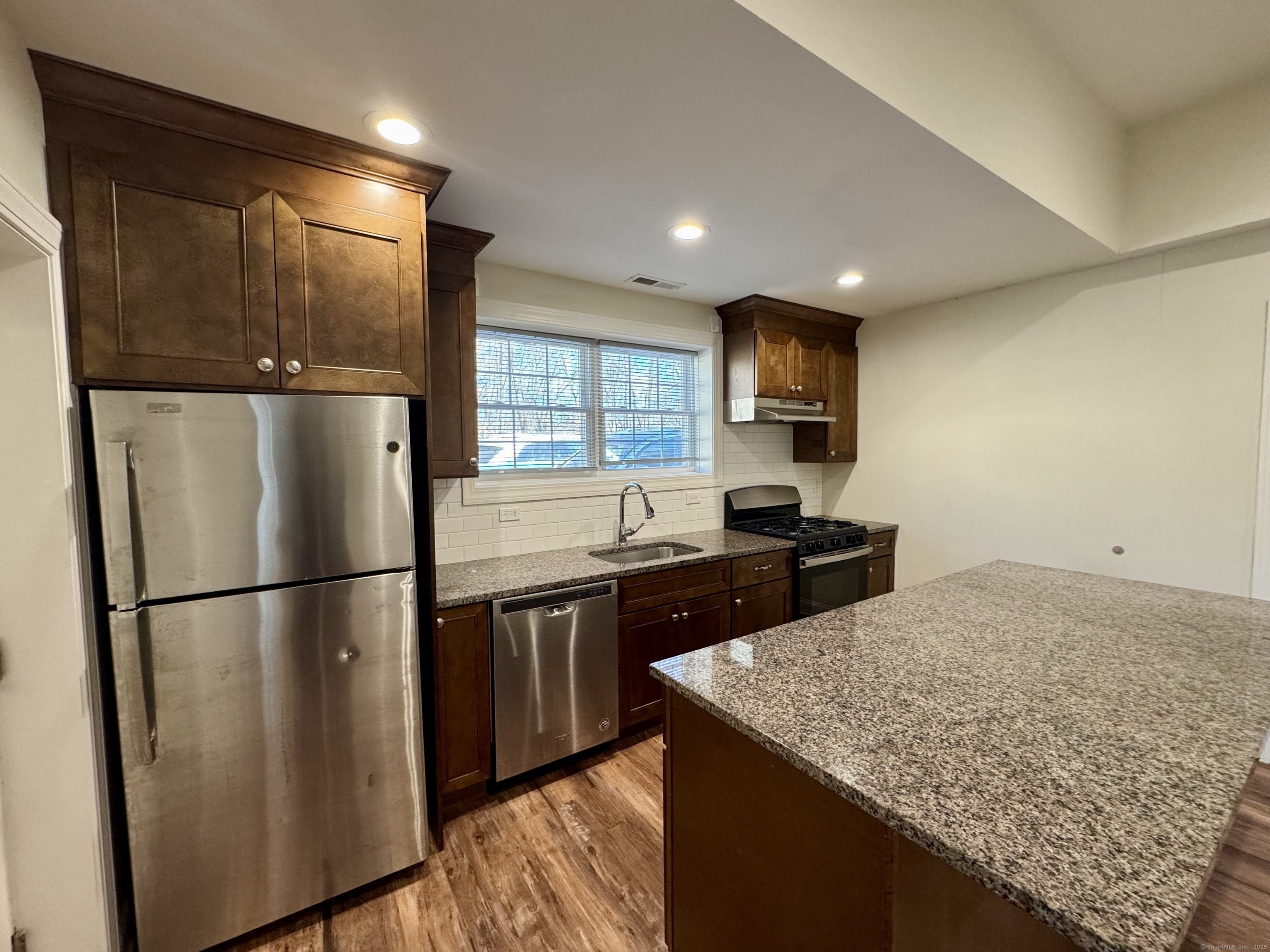 950 Lindley Street Bridgeport, CT 06606 - Photo 3 of 14 a kitchen with stainless steel appliances granite countertop a refrigerator and a sink