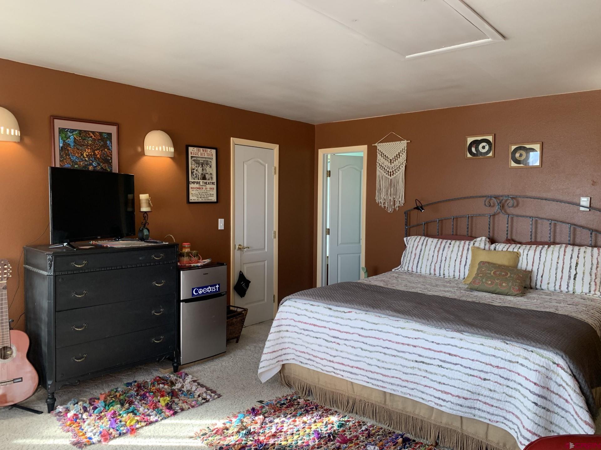 17679 2550 Road Cedaredge, CO 81413 - Photo 27 of 35 a bedroom with a bed and a television