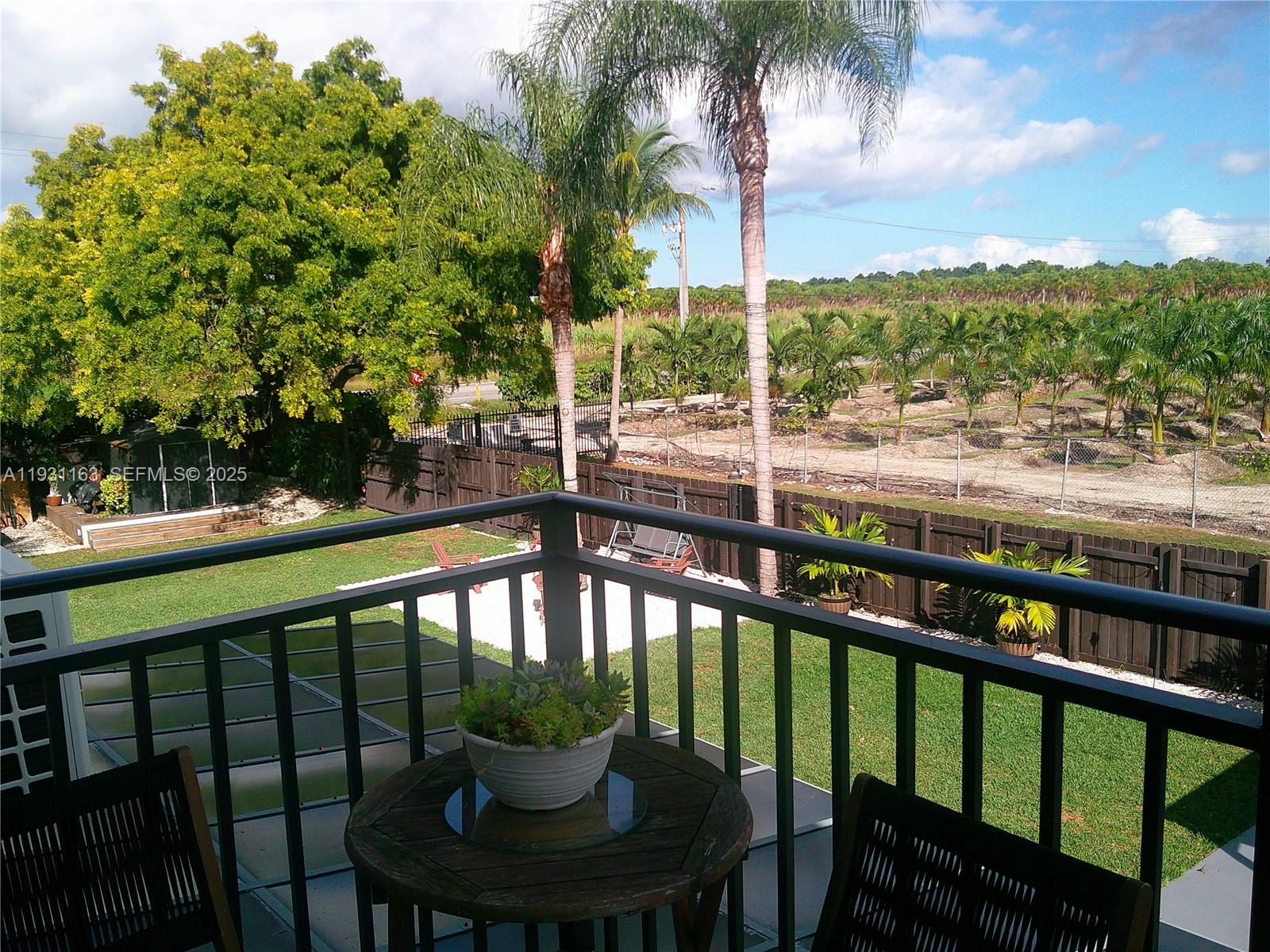 26831 Southwest 119th Court Homestead, FL 33032 - Photo 13 of 27 a view of roof deck with seating area and trees around