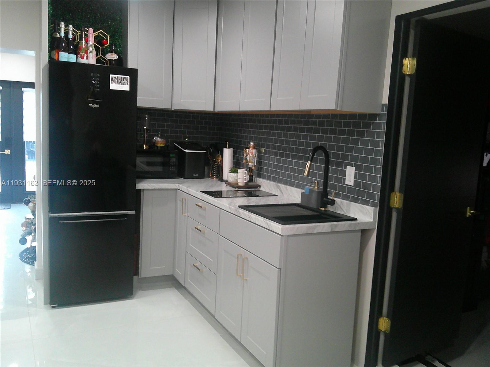 26831 Southwest 119th Court Homestead, FL 33032 - Photo 17 of 27 a kitchen with a refrigerator and cabinets