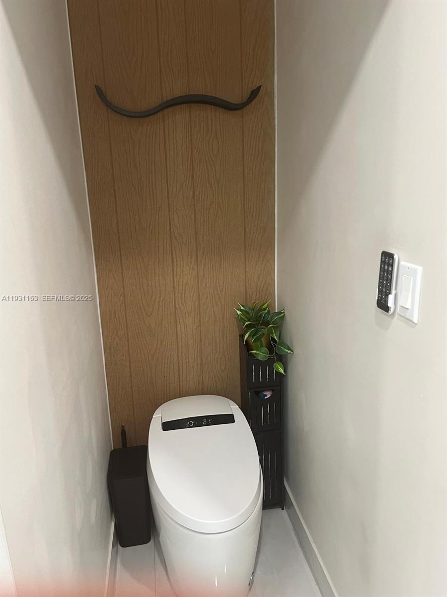 26831 Southwest 119th Court Homestead, FL 33032 - Photo 23 of 27 a white toilet sitting next to a wooden wall