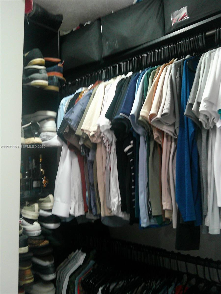 26831 Southwest 119th Court Homestead, FL 33032 - Photo 24 of 27 a view of walk in closet with clothes and shoes