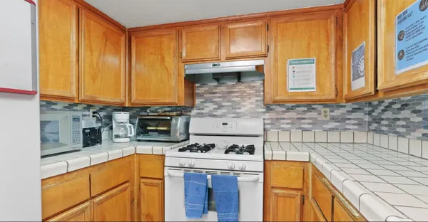 a kitchen with stainless steel appliances granite countertop a stove a sink and a microwave