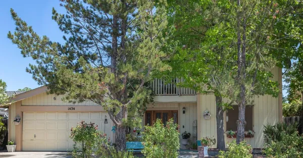 a front view of a house with a tree