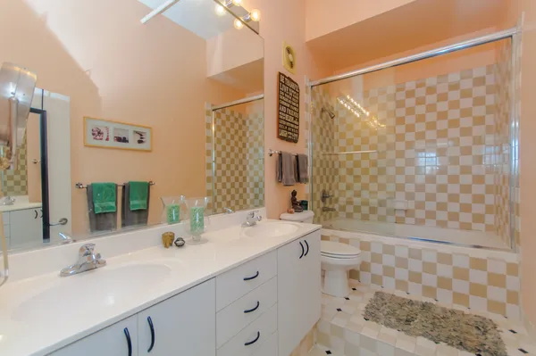 a bathroom with a double vanity sink toilet and shower