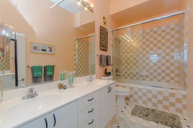 a bathroom with a double vanity sink toilet and shower