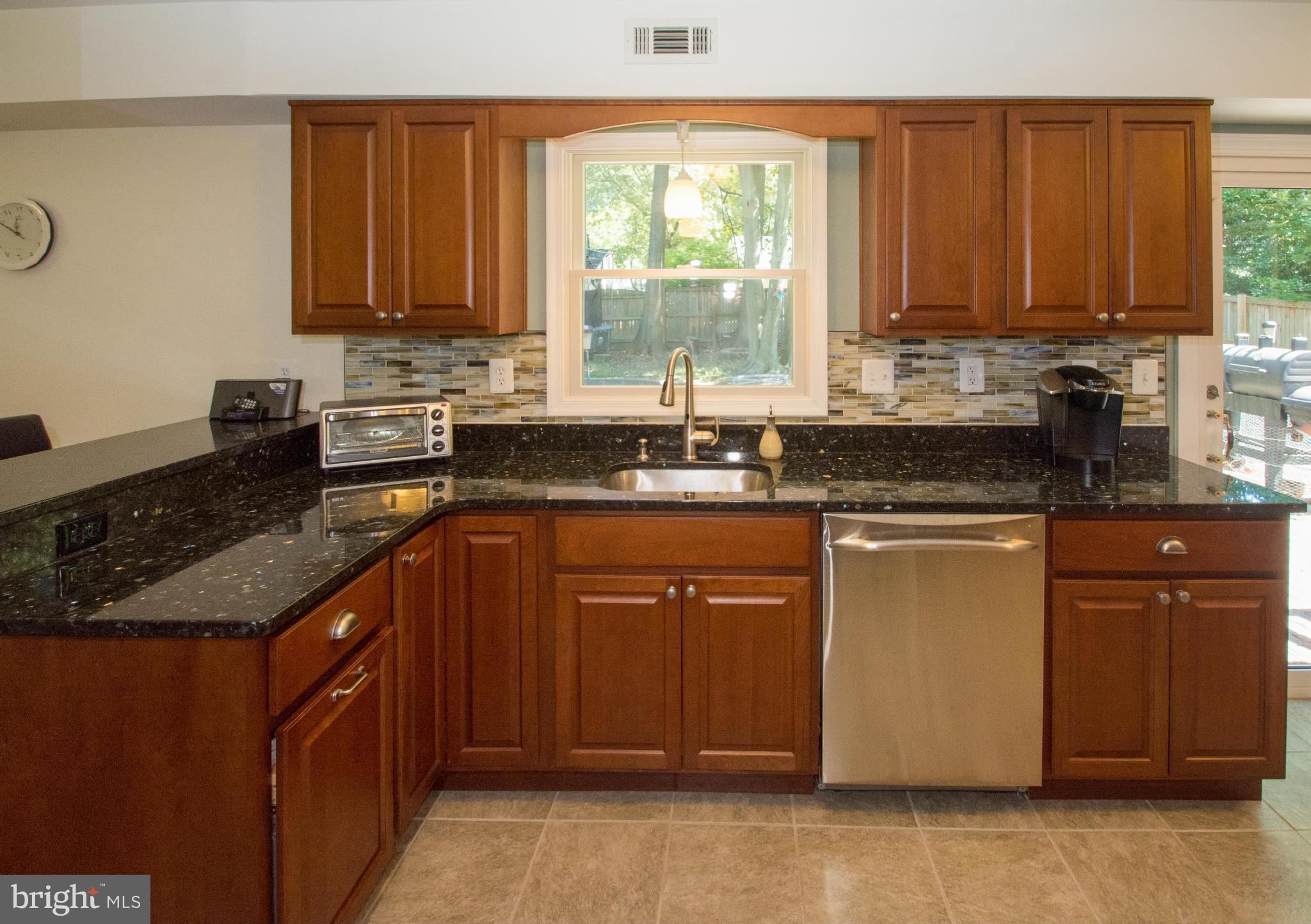 1712 Tarleton Way Crofton, MD 21114 - Photo 3 of 26 a kitchen with granite countertop wooden cabinets stainless steel appliances a sink and a window