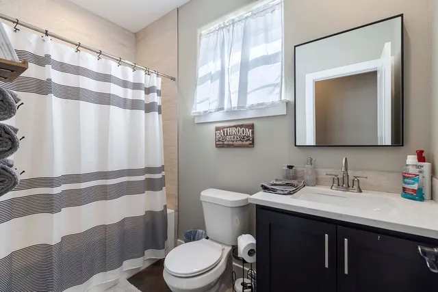 a bathroom with a toilet a sink and a mirror
