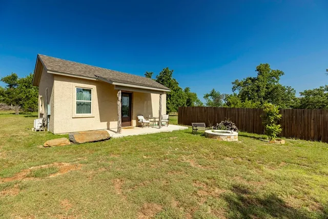 a view of a house with backyard and sitting area