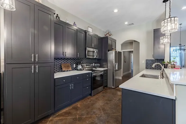 a kitchen with stainless steel appliances granite countertop a refrigerator and a sink