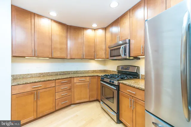 a kitchen with stainless steel appliances granite countertop a sink stove and cabinets