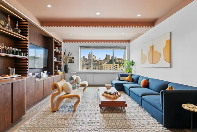 a living room with furniture a rug and a flat screen tv