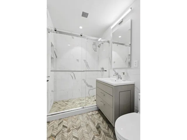 a bathroom with a sink a toilet and shower