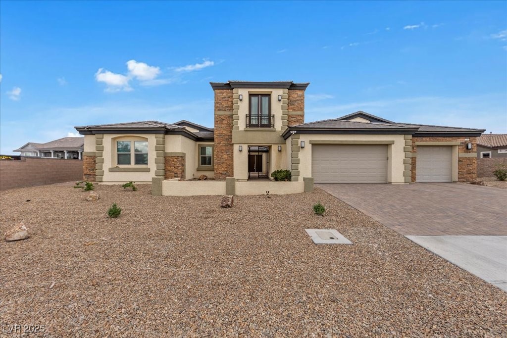 259 Milan Street Henderson, NV 89015 - Photo 2 of 99 View of front of home featuring stucco siding, stone siding, decorative driveway, and a garage