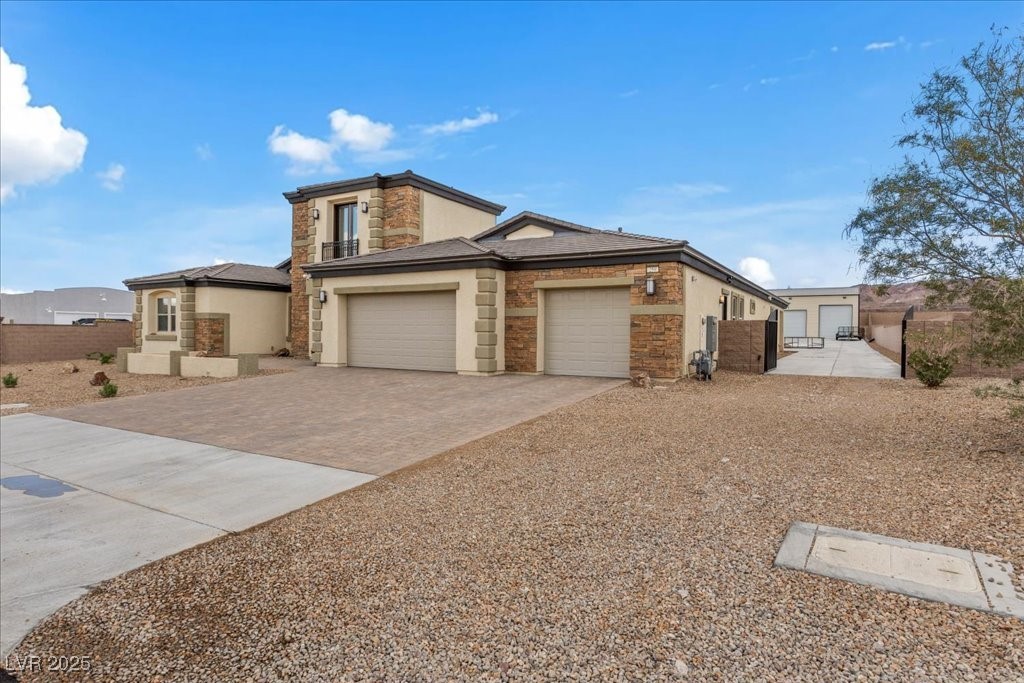 259 Milan Street Henderson, NV 89015 - Photo 3 of 99 View of front of house with stone siding, driveway, stucco siding, and a garage