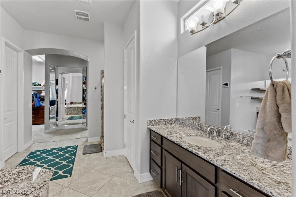 259 Milan Street Henderson, NV 89015 - Photo 33 of 99 Full bath featuring vanity, light tile patterned floors, and a closet