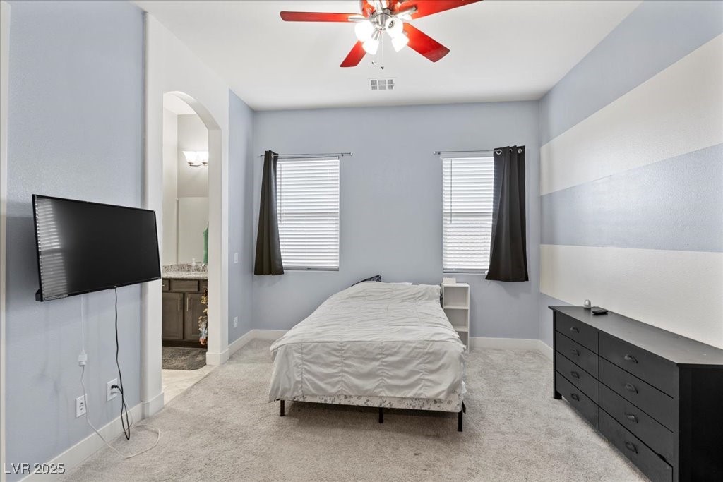 259 Milan Street Henderson, NV 89015 - Photo 37 of 99 Bedroom featuring light carpet, ensuite bathroom, a ceiling fan, and arched walkways