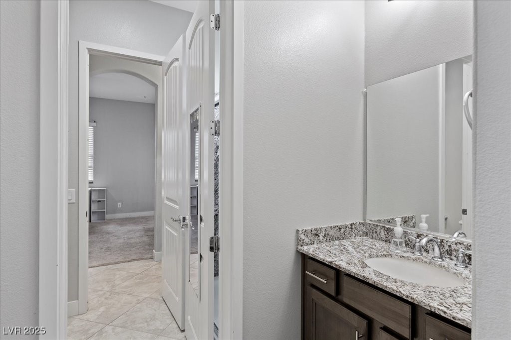 259 Milan Street Henderson, NV 89015 - Photo 42 of 99 Bathroom featuring vanity, a textured wall, and light tile patterned floors