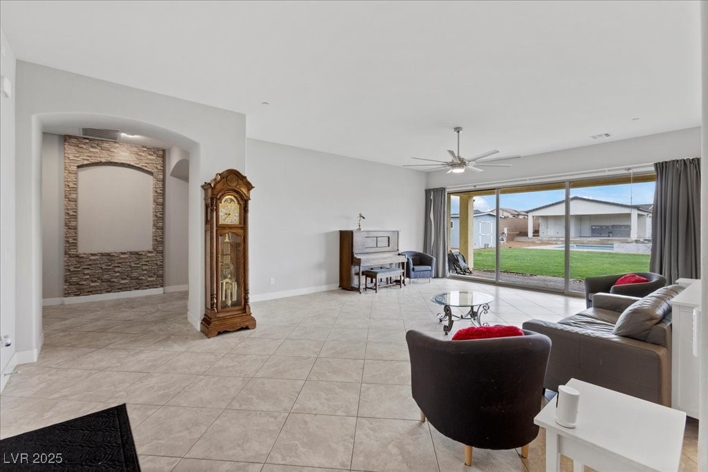 259 Milan Street Henderson, NV 89015 - Photo 8 of 99 Living area featuring ceiling fan, light tile patterned floors, and arched walkways