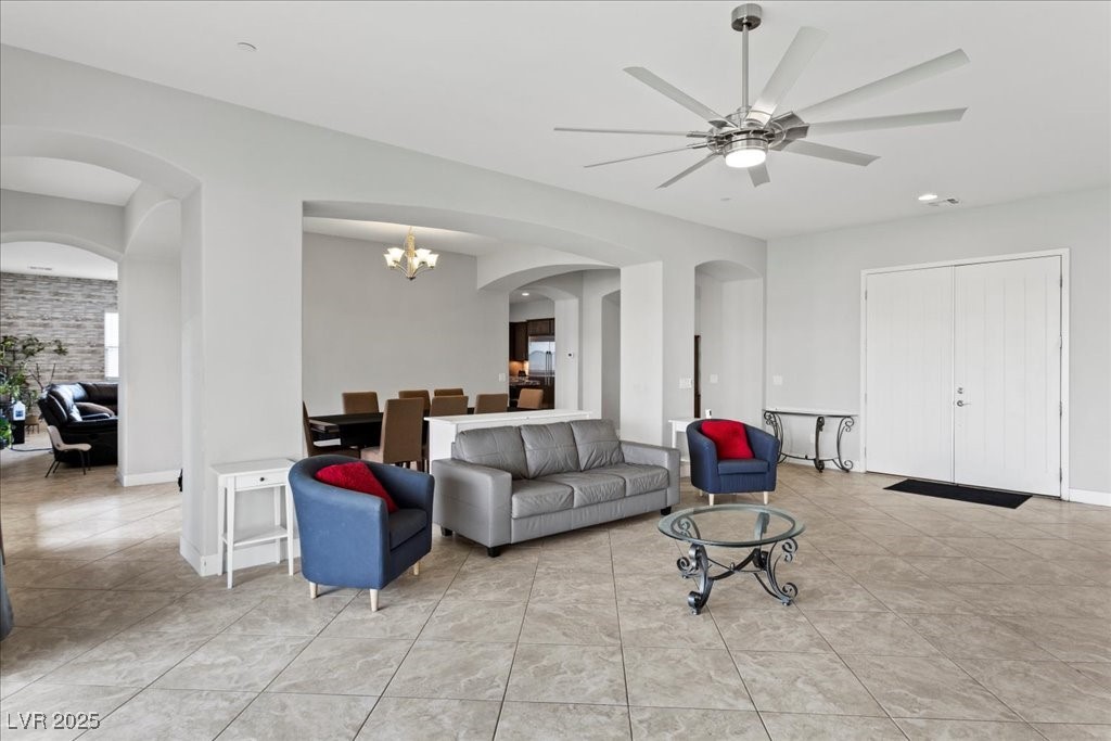 259 Milan Street Henderson, NV 89015 - Photo 9 of 99 Living area with arched walkways, a chandelier, light tile patterned floors, a ceiling fan, and recessed lighting
