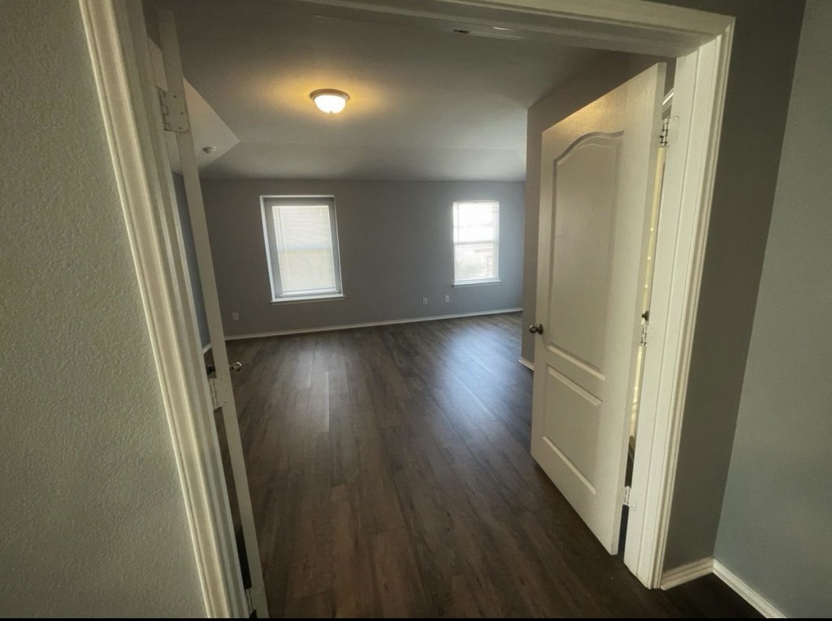 13905 Inaugural Street Manor, TX 78653 - Photo 13 of 26 Hallway featuring baseboards and dark wood-style flooring