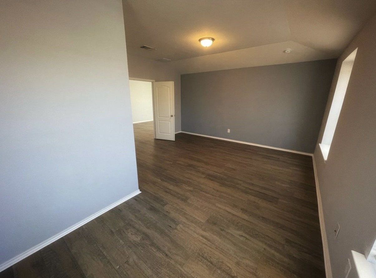 13905 Inaugural Street Manor, TX 78653 - Photo 15 of 26 Empty room with baseboards and dark wood-style flooring